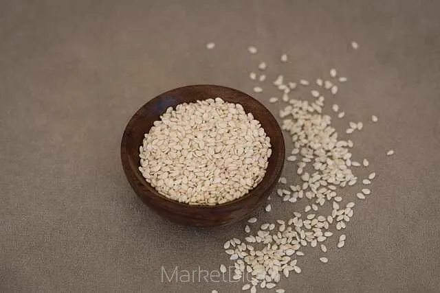Biała miseczka wypełniona ziarnami sezamu jako dodatek do potraw